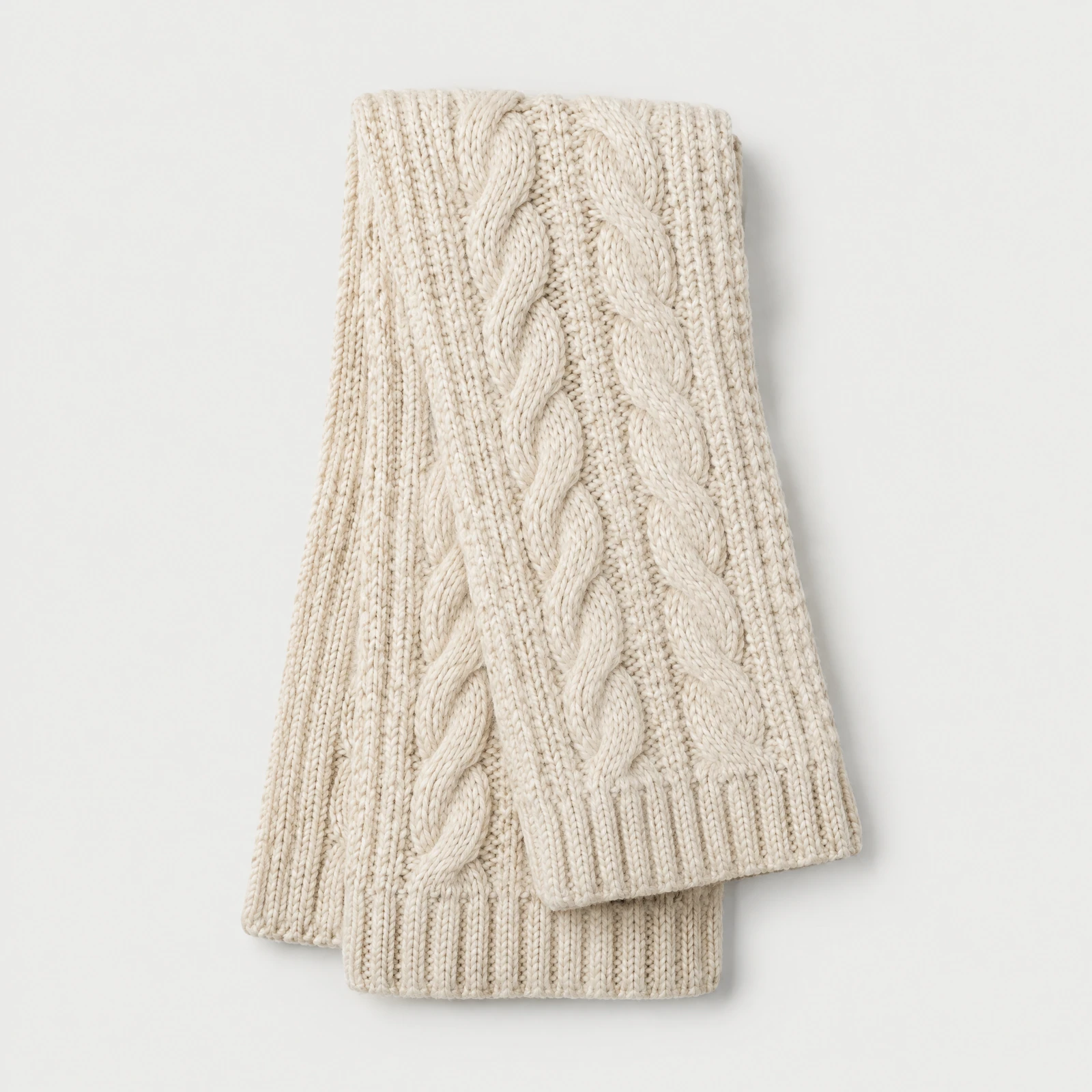Thick cream cable scarf folded flat on a light gray background