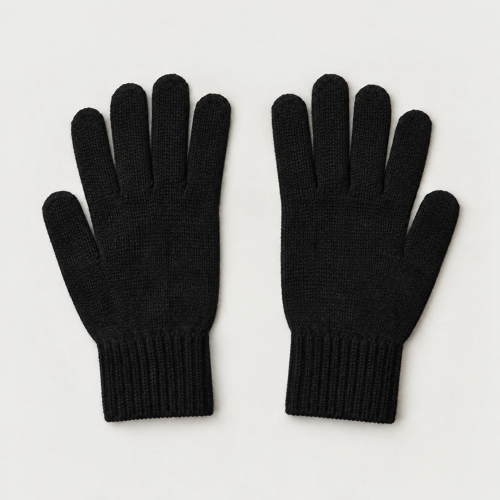 One pair of black gloves with ribbed cuffs laid flat with the fingers pointing up on a light gray background
